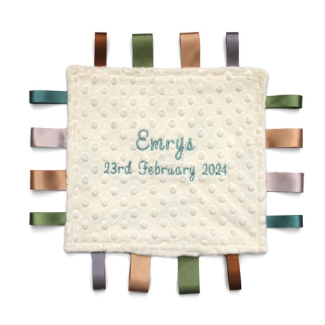 Baby comfort blanket with embroidered name and date on a white background