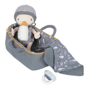 A soft plush baby doll named Jim sitting in a carry basket with a blanket and bottle, all in gray tones with yellow accents.