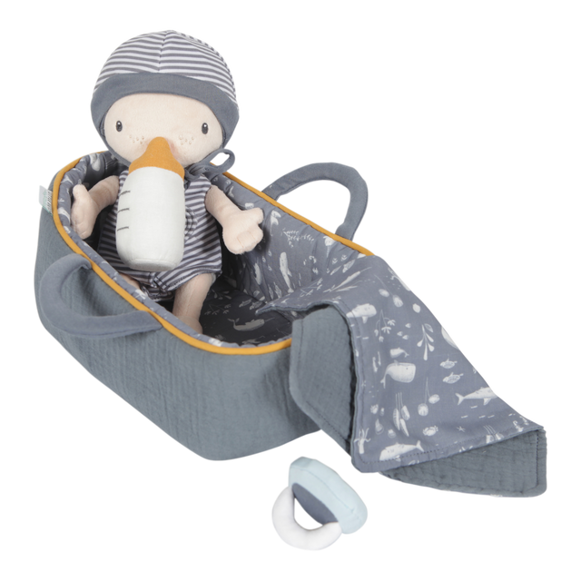 A soft plush baby doll named Jim sitting in a carry basket with a blanket and bottle, all in gray tones with yellow accents.