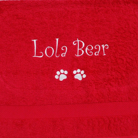 A large red personalised Dog Towel with name and dog paws