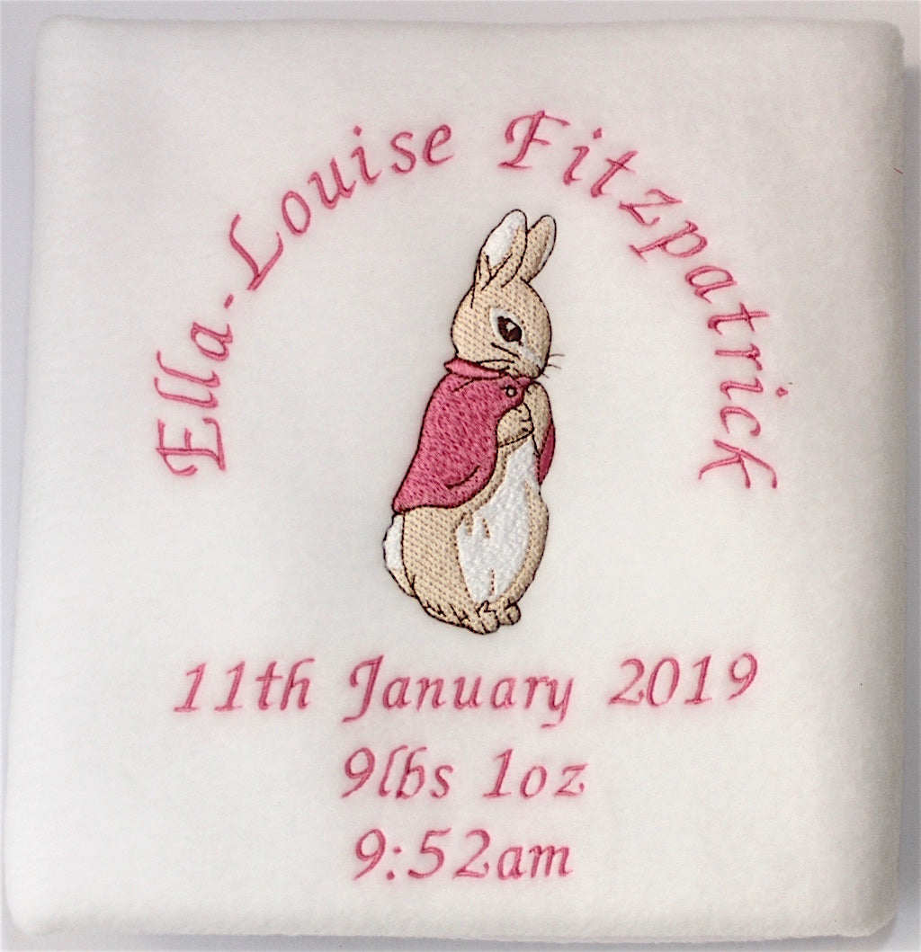 A folded beautifully handmade personalised and embroidered Beatrix Potter Flopsy Bunny Blanket with name and date around the bunny  