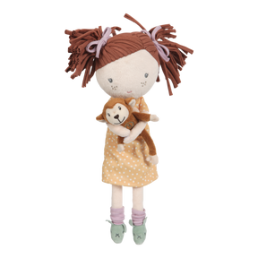 A plush doll depicting a girl with brown hair holding a small toy monkey. The doll has a soft body, with the girl's outfit featuring a polka-dot design and a brown bow.