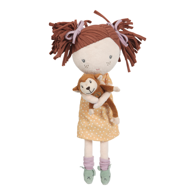 A plush doll depicting a girl with brown hair holding a small toy monkey. The doll has a soft body, with the girl's outfit featuring a polka-dot design and a brown bow.