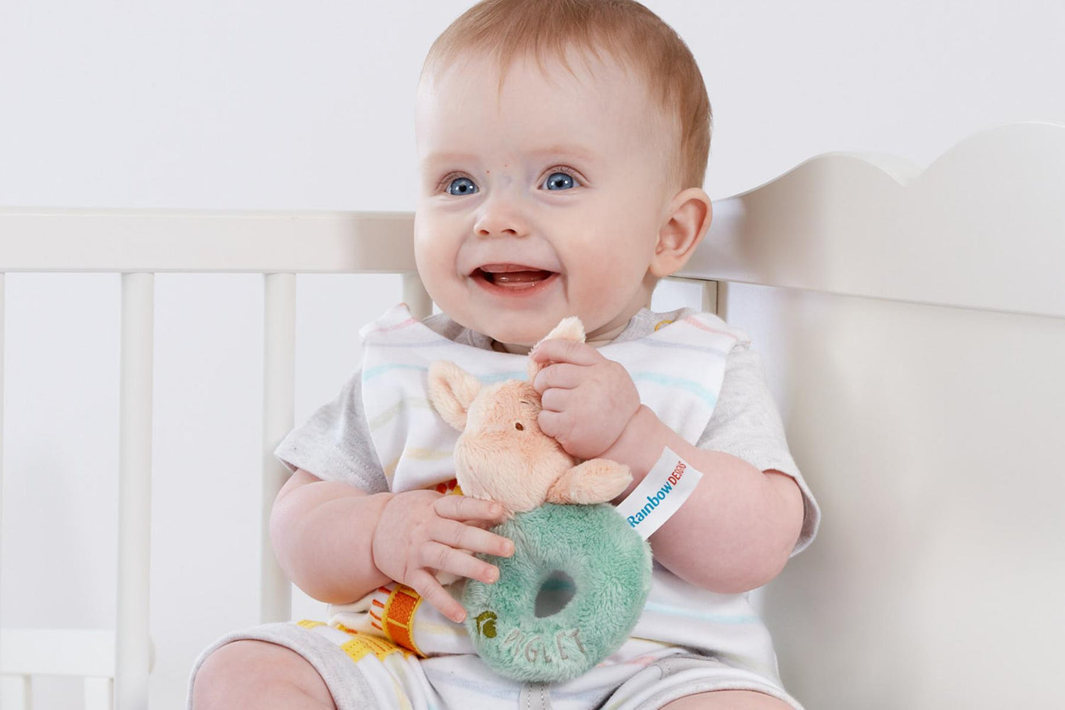 Baby holding a Hundred Acre Wood Piglet Ring Rattle