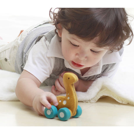 child playing with a Plan Toys Dino eco friendly car