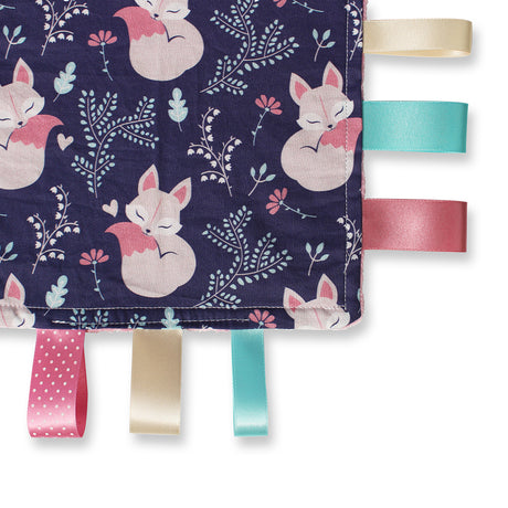 A corner picture of a beautiful personalised Sleepy Fox Taggy Comforter with colourful ribbons and fox fabric also showing the rear pink minky fabric
