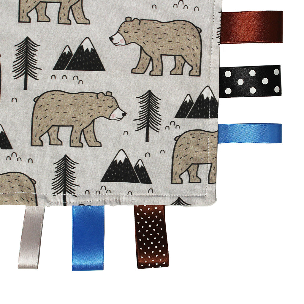 Close up of Hedgehog Gifts newborn baby gift handmade mountain bear taggy comforter blanket with satin ribbons in blue brown grey