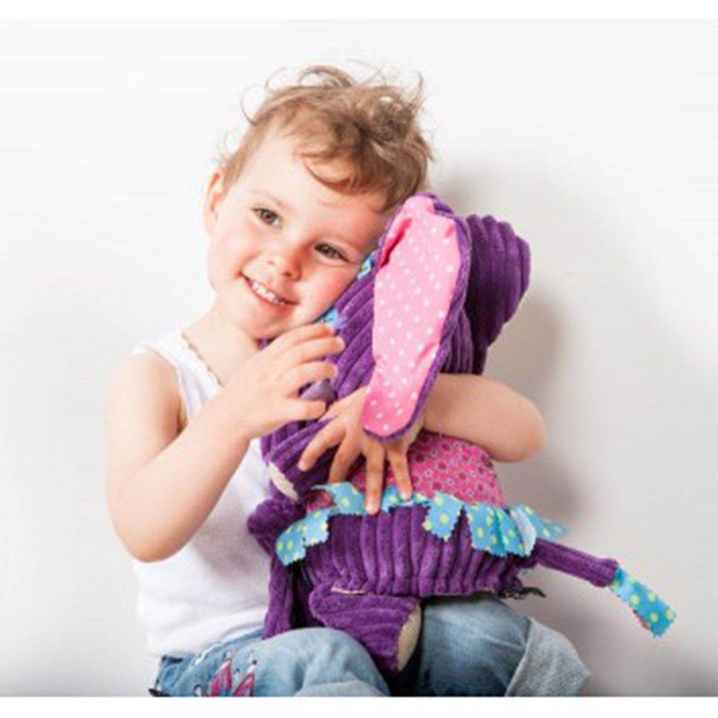 Happy child hugging a adorable Deglingos Original Elephant with pink top, blue dress, huge pink and cream ears and a long purple nose