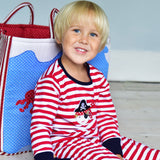 A young lad with a red and white striped pirate pyjamas suit by Powell Craft